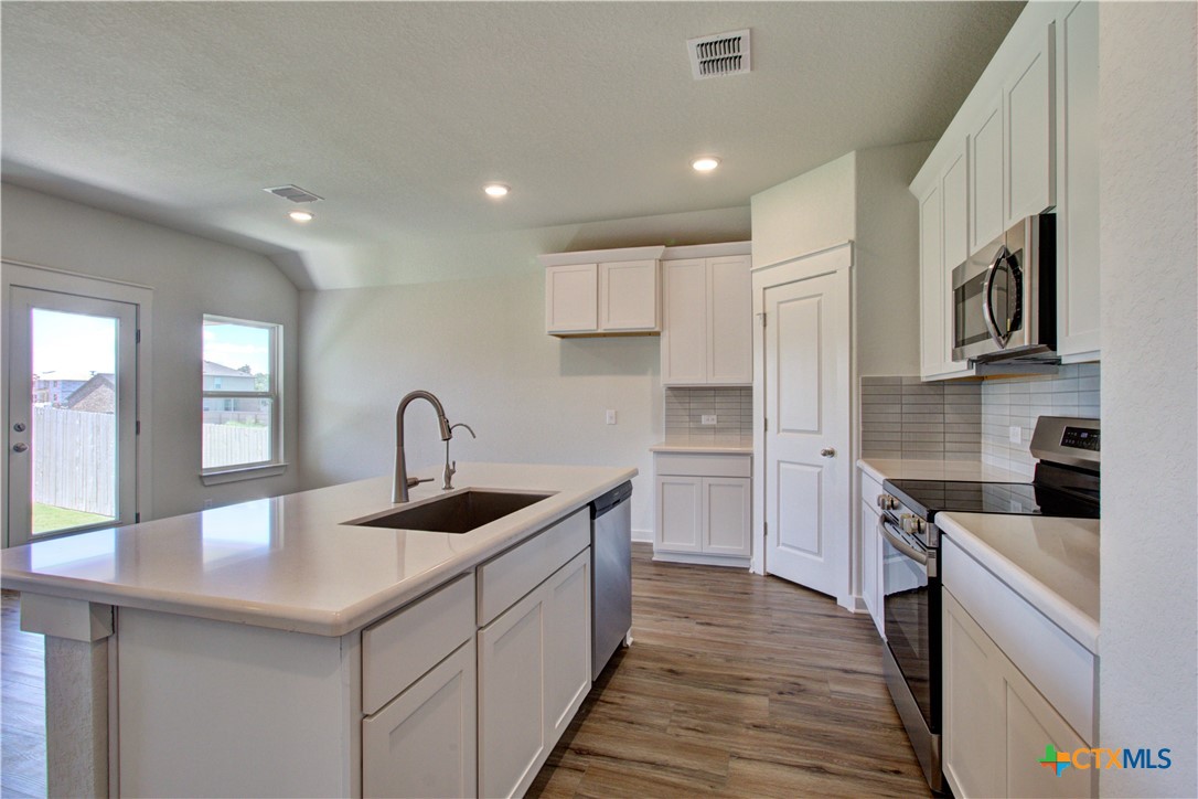 a kitchen with sink cabinets and stove