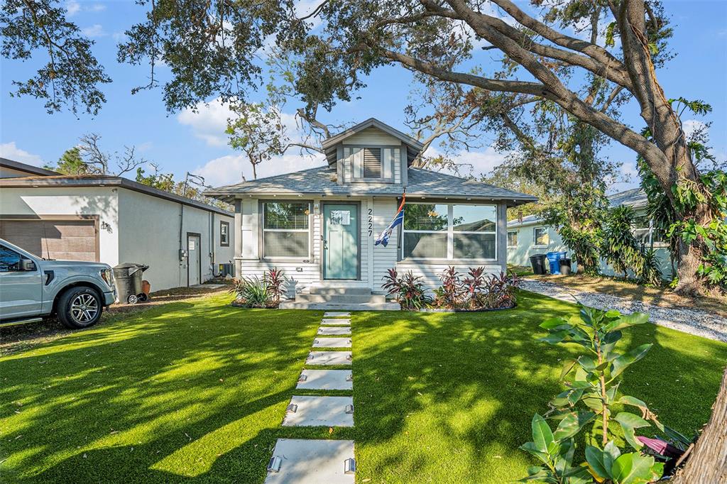 a front view of a house with swimming pool and garden