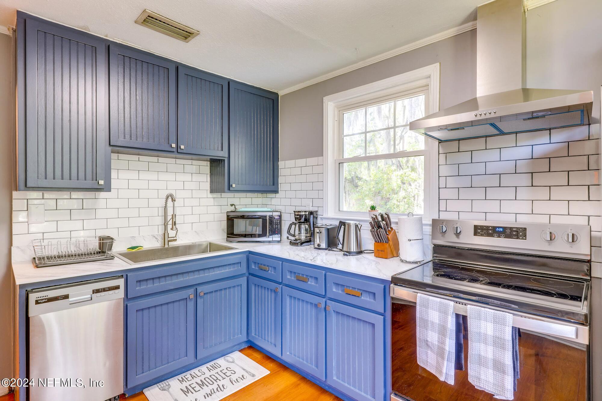 a kitchen with stainless steel appliances wooden cabinets and a stove top oven