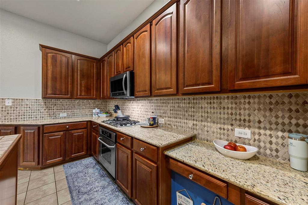 a kitchen with stainless steel appliances granite countertop wooden cabinets a sink and dishwasher