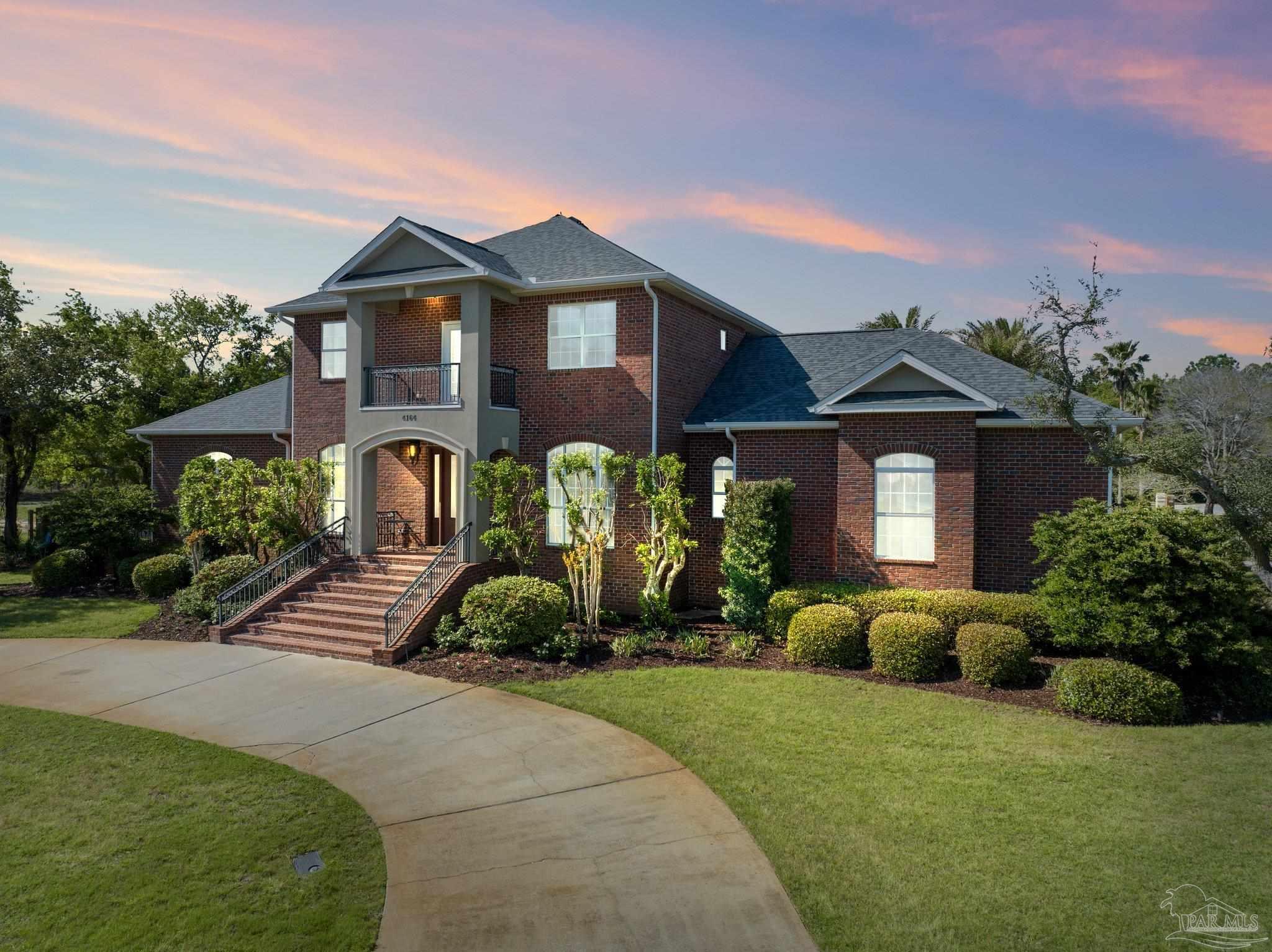 a front view of a house with a yard and potted plants