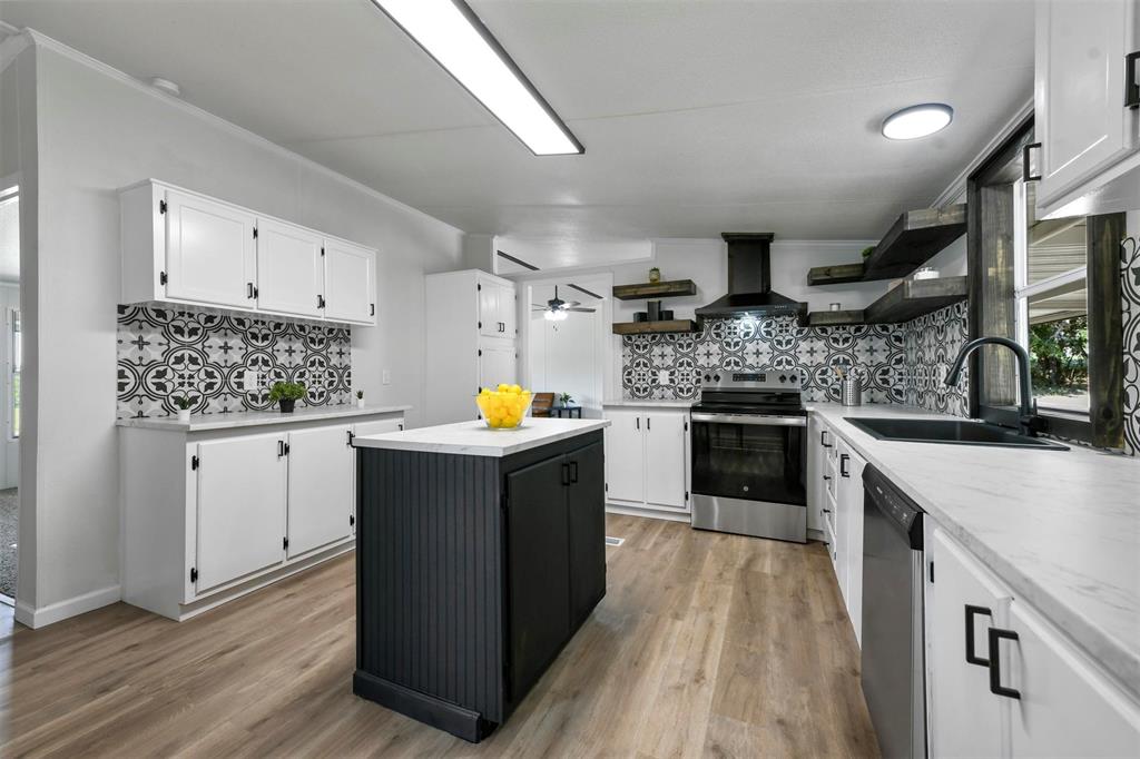 a kitchen with stainless steel appliances granite countertop a stove a sink dishwasher and a refrigerator