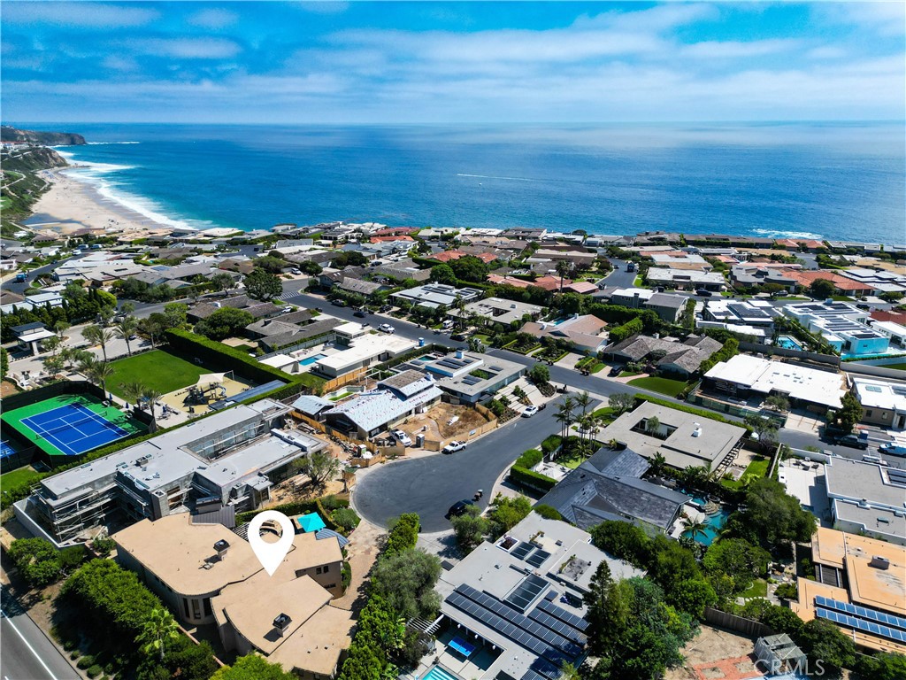 an aerial view of a city with ocean view in back