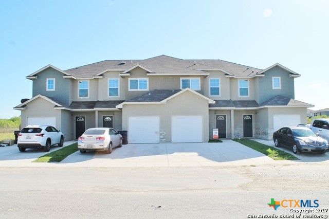 a front view of a house with a parking space