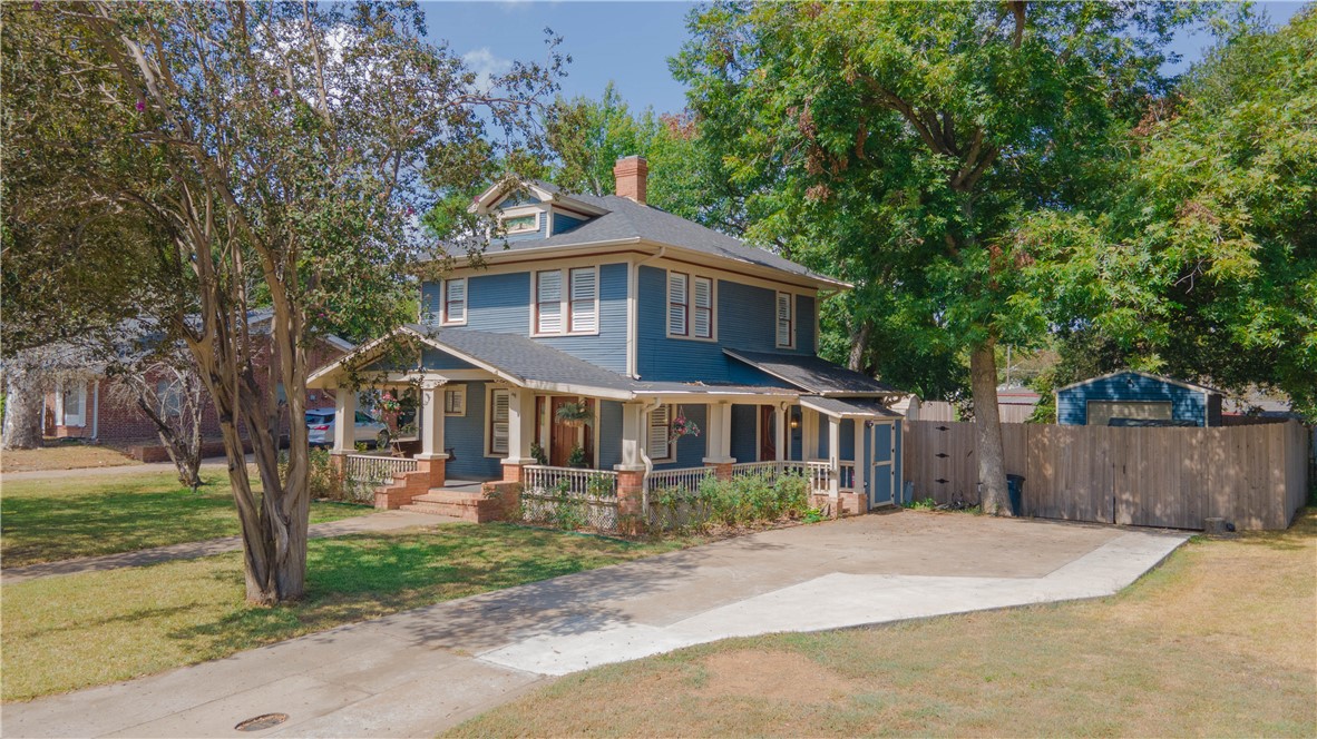 a front view of a house with a yard and trees