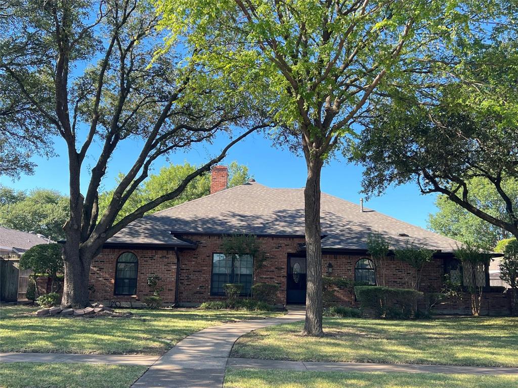 a front view of a house with a tree