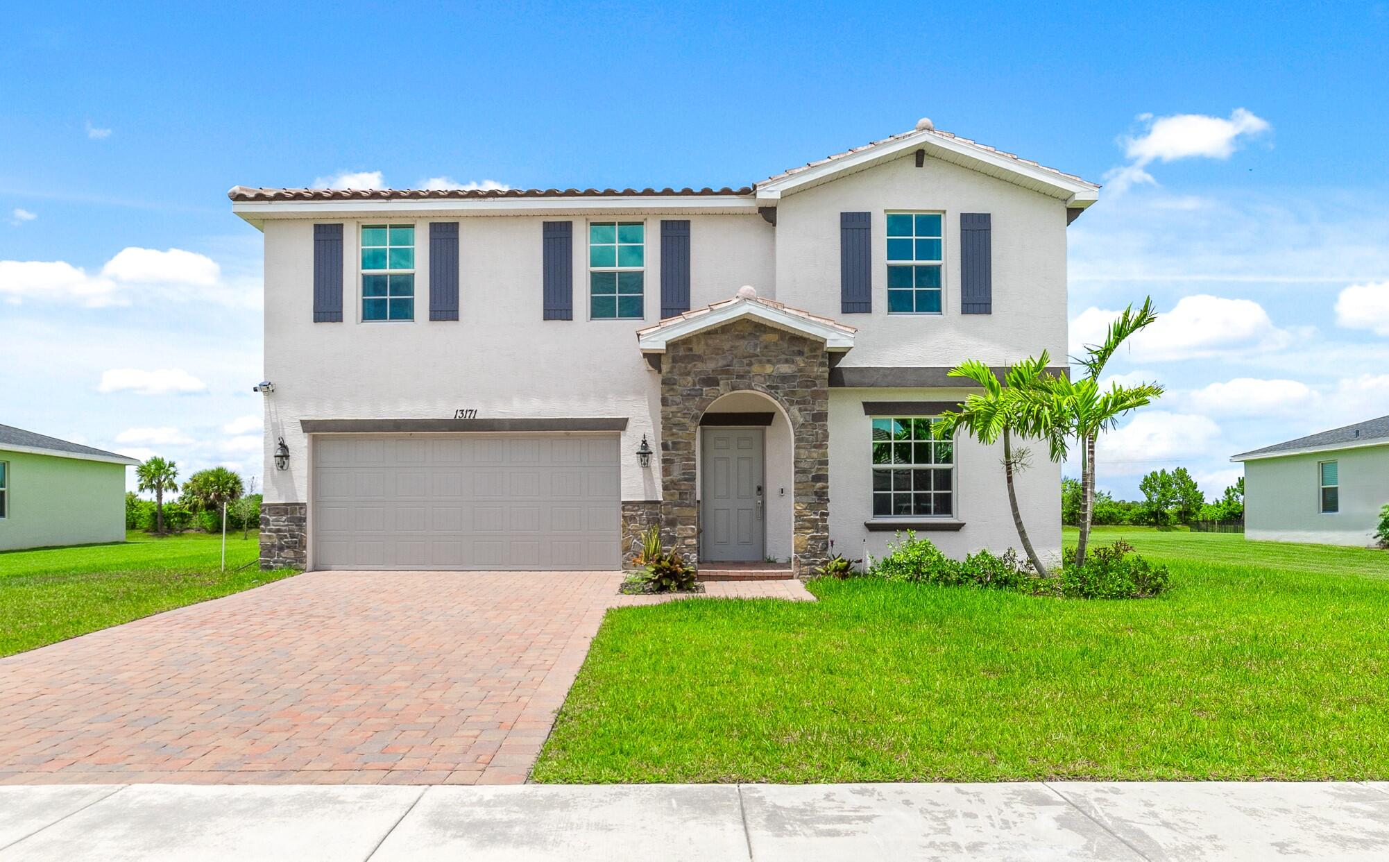 a front view of a house with a yard and garage