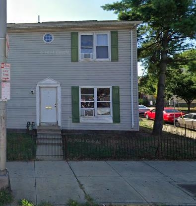 a view of a house with a small yard and large trees