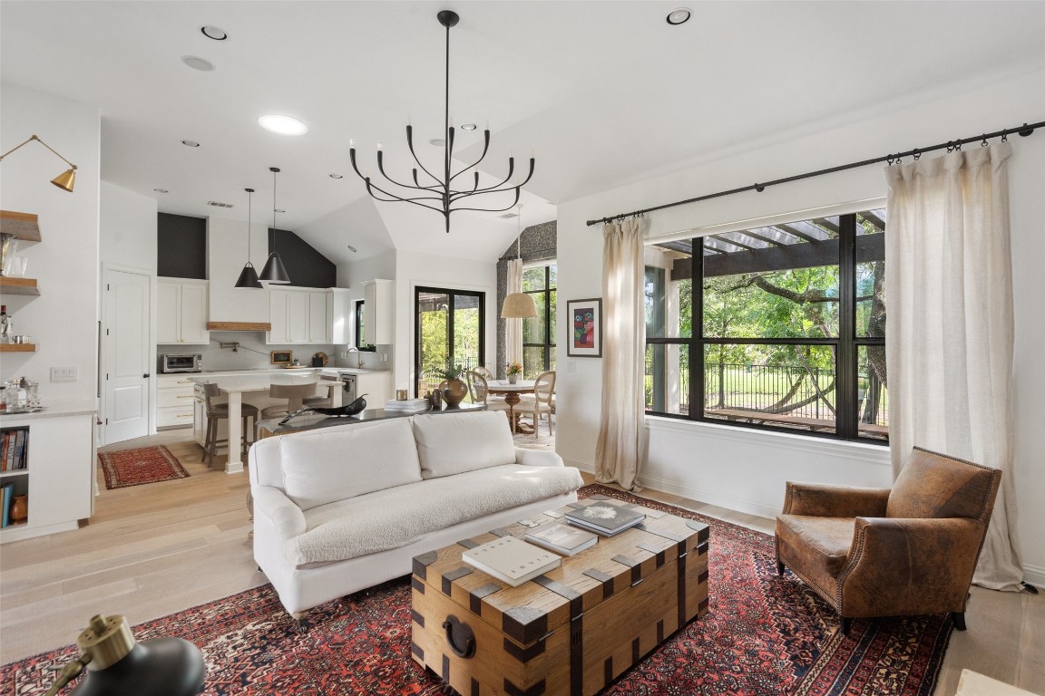 a living room with furniture a chandelier and a dining table