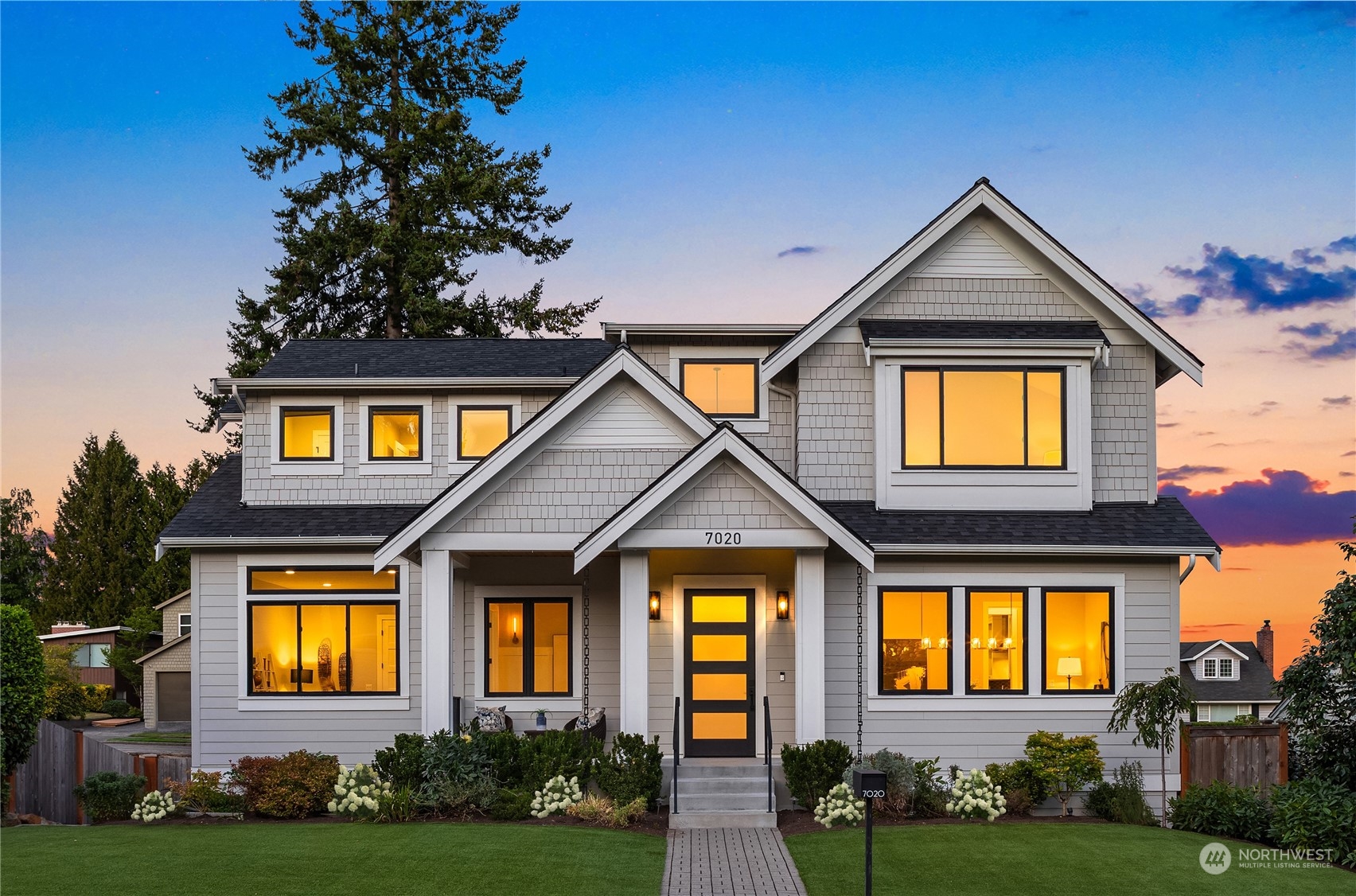 a front view of a house with yard and green space