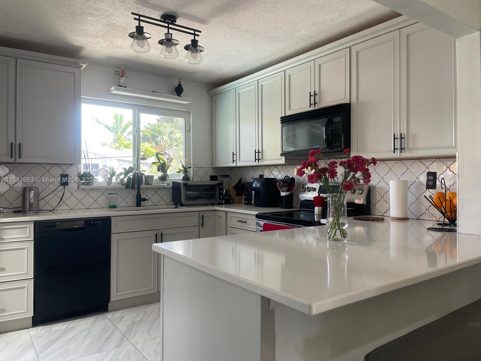 a kitchen with sink a window and appliances