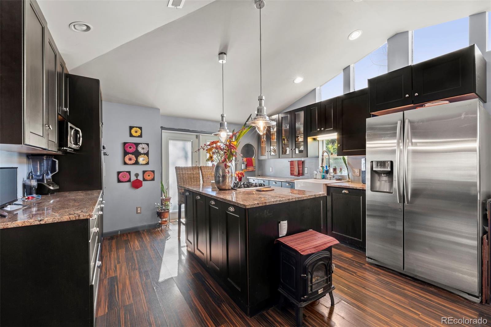 a kitchen with a refrigerator a stove and wooden floor