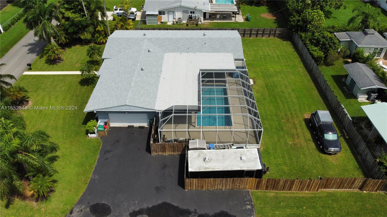 an aerial view of a residential houses with outdoor space and trees