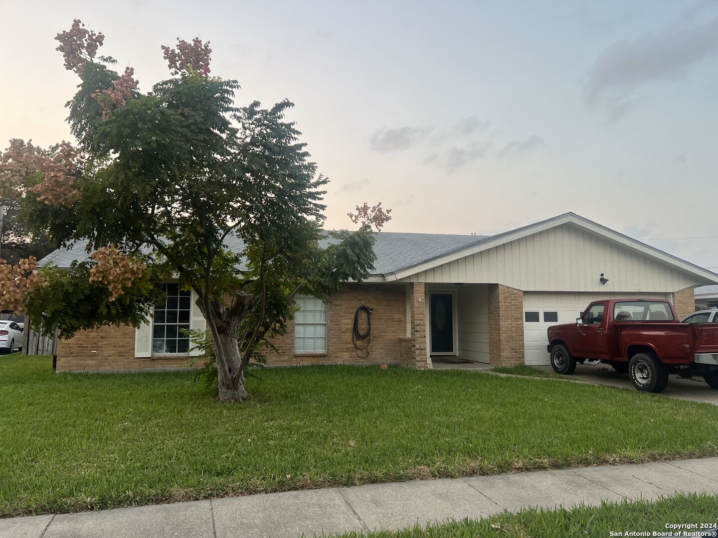 a front view of a house with a garden and yard