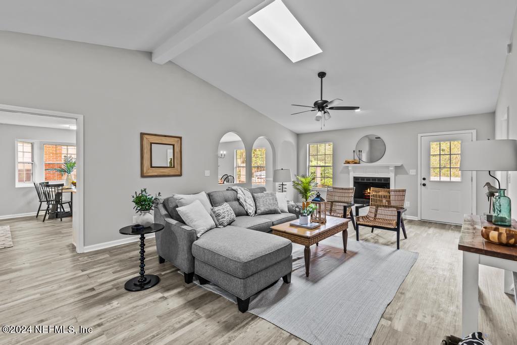 a living room with furniture a fireplace and wooden floor