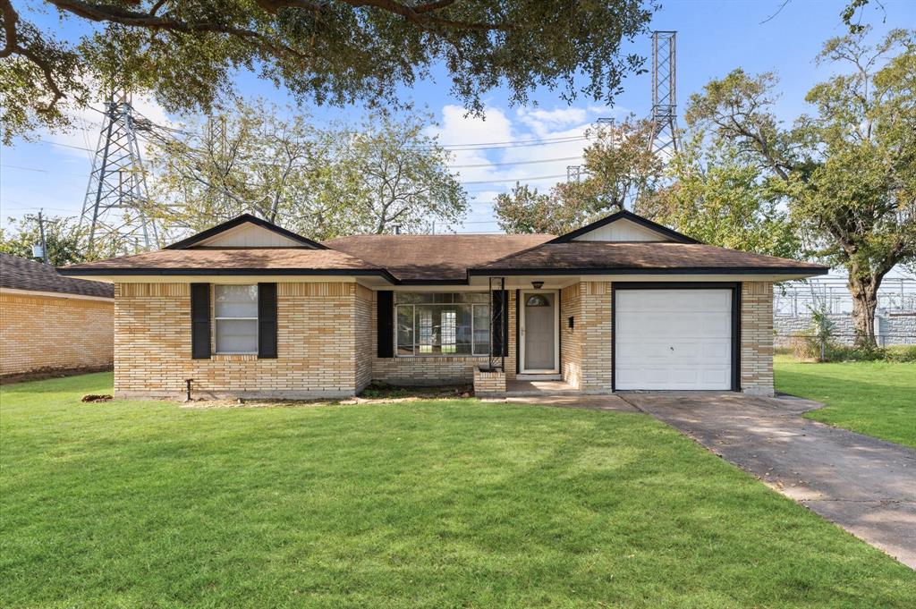 a front view of a house with a yard and trees