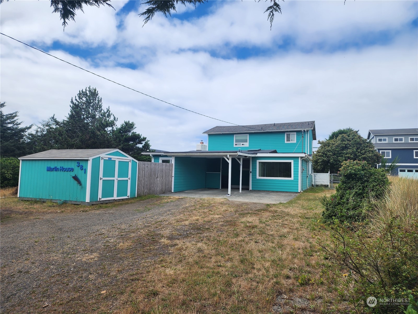 a front view of house with yard and trees in the background