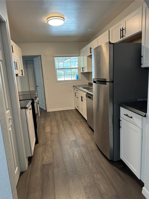 a kitchen with white cabinets and white stainless steel appliances