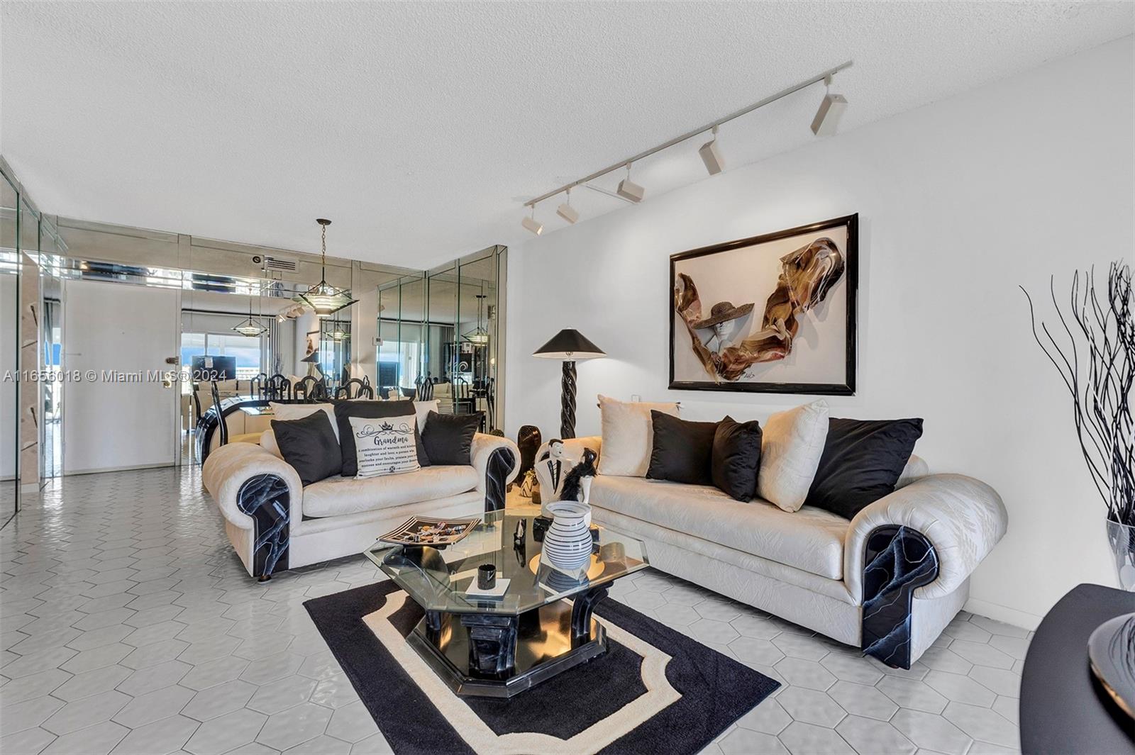 a living room with furniture couches and a dining table with wooden floor