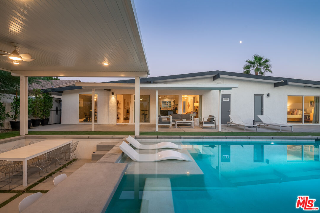 a view of a house with swimming pool and sitting area