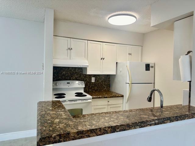 a kitchen with granite countertop a stove a refrigerator and a sink