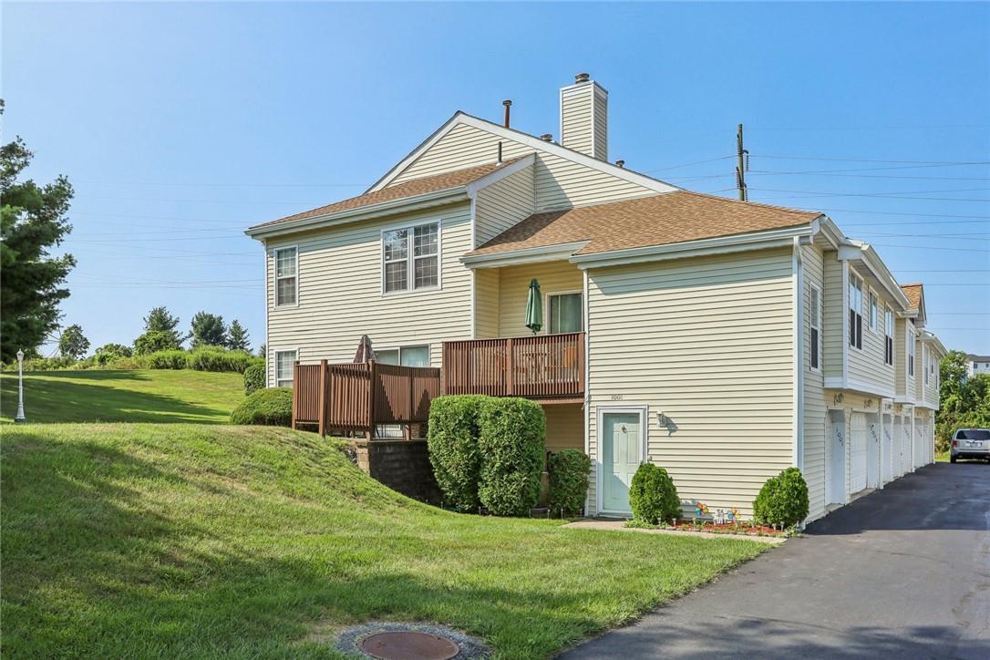 Rear view of house featuring a garage and a lawn