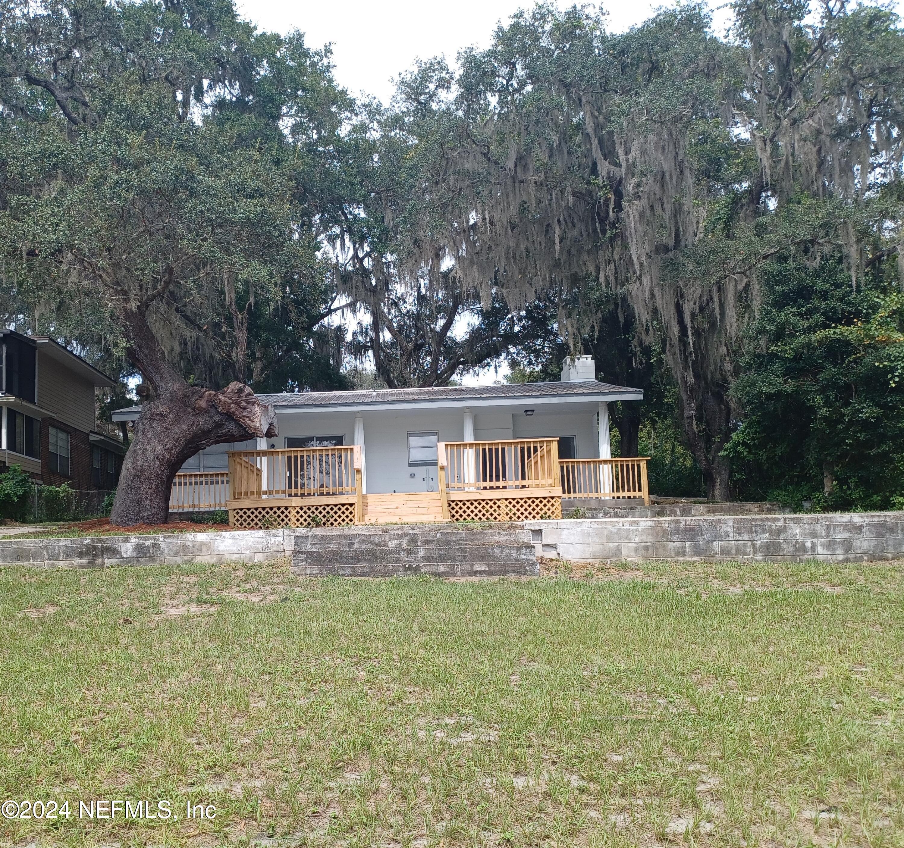 a front view of house with yard and trees in the background