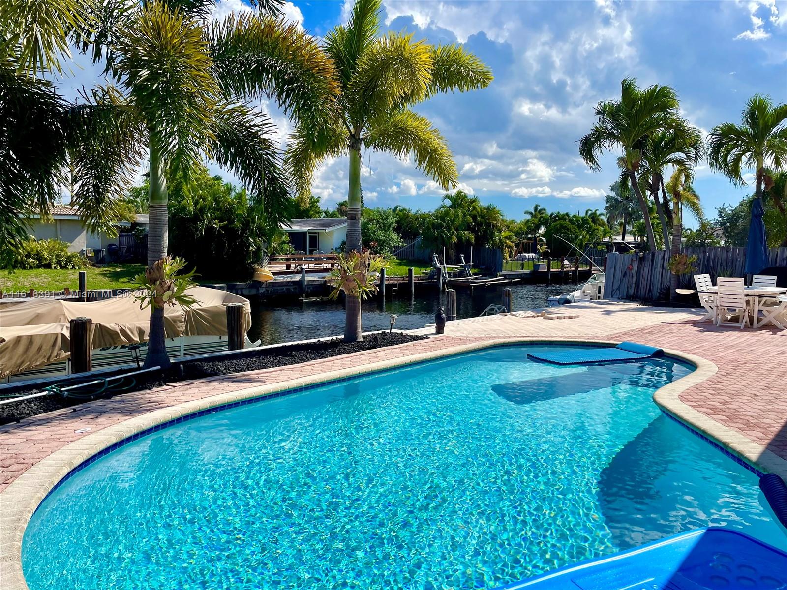 a swimming pool with outdoor seating and yard