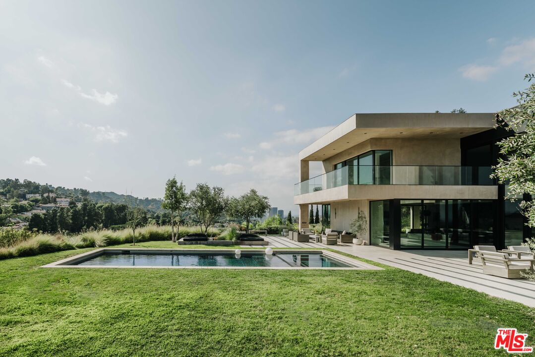 a front view of a house with swimming pool having outdoor seating