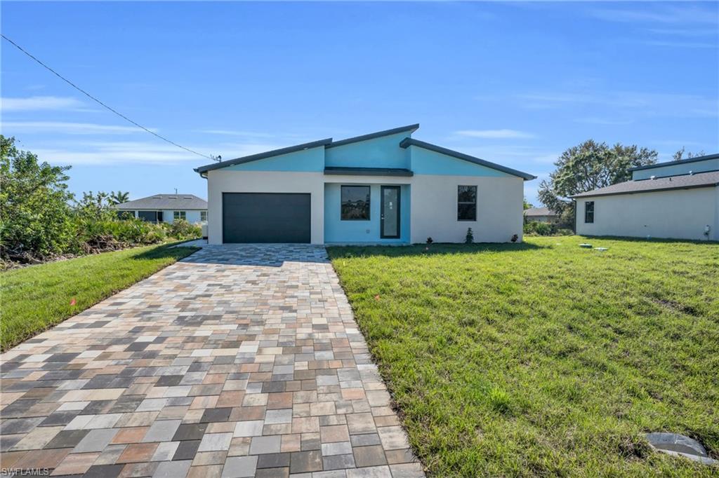 View of front of property with a front lawn and a garage