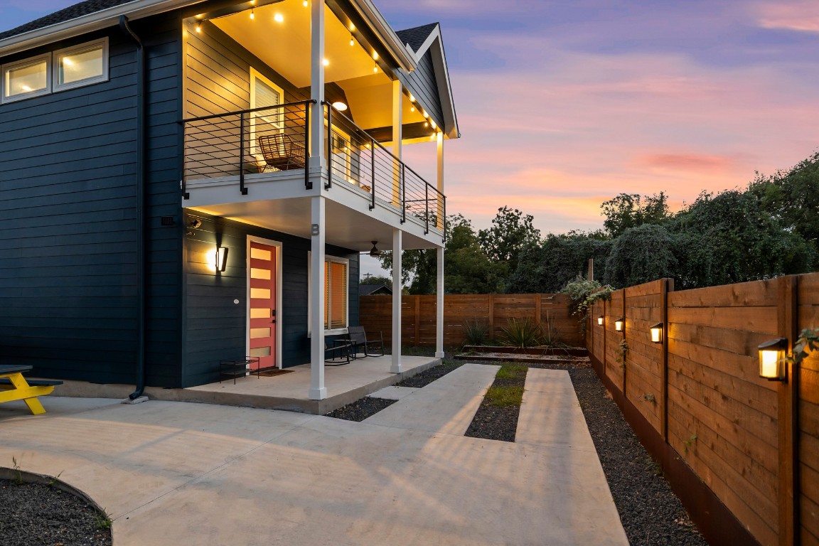 a view of a house with a floor to ceiling window and wooden fence