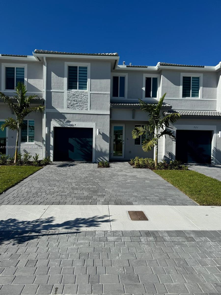 a front view of a house with a yard and a garage