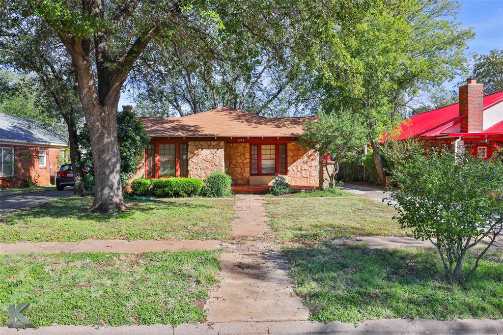 a front view of a house with a yard and trees