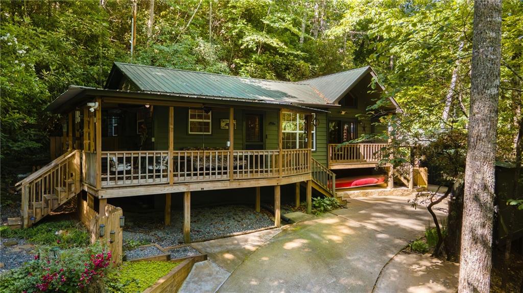 a view of a house with wooden deck and furniture