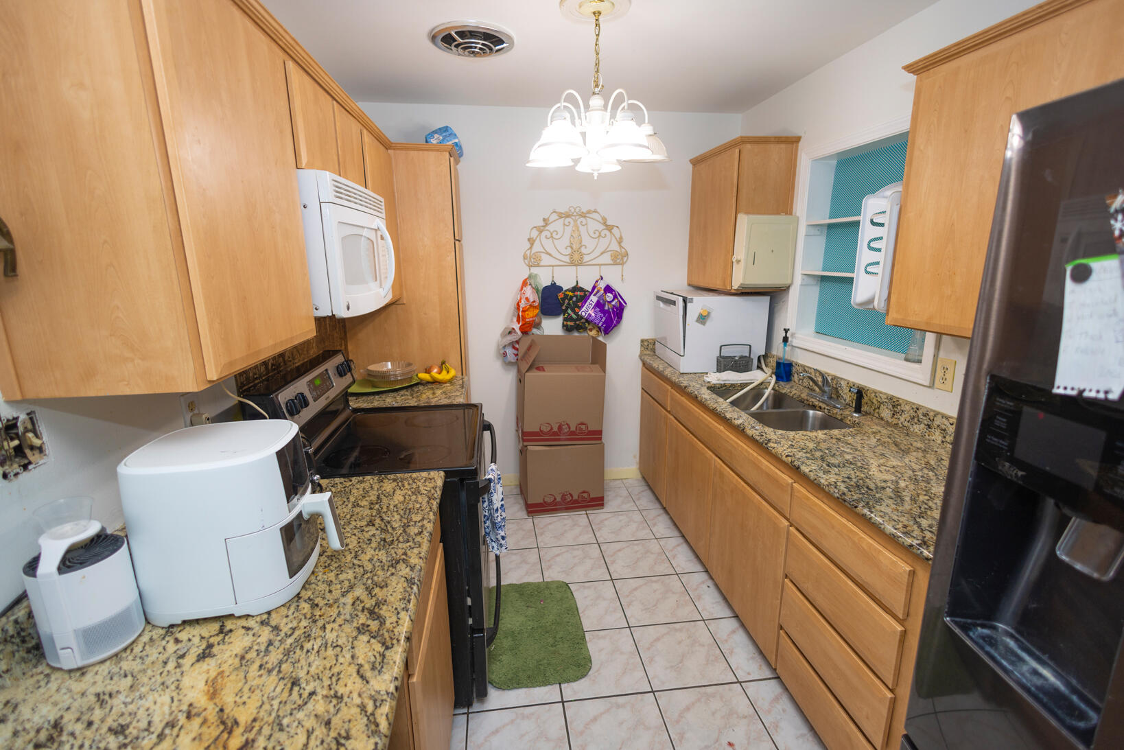 a large kitchen with kitchen island granite countertop a sink stove and refrigerator