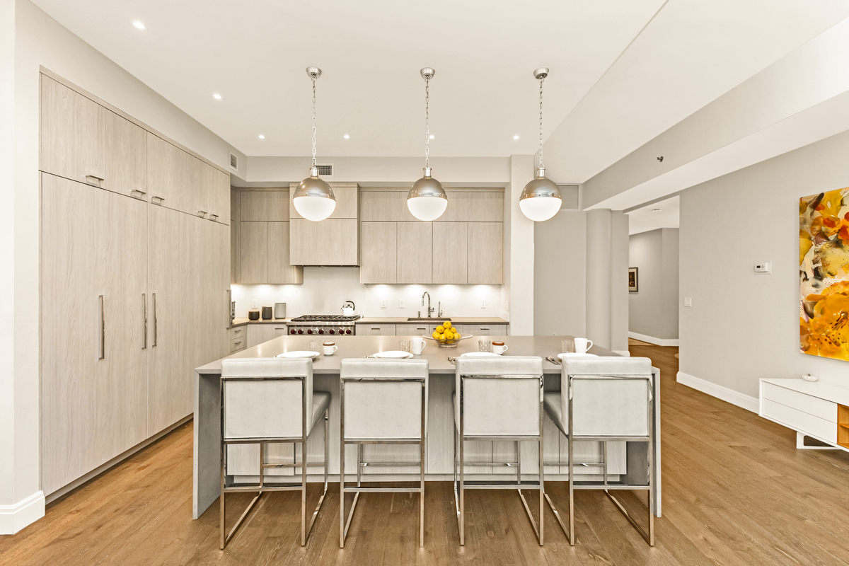 a kitchen with a dining table chairs wooden floor and white cabinets