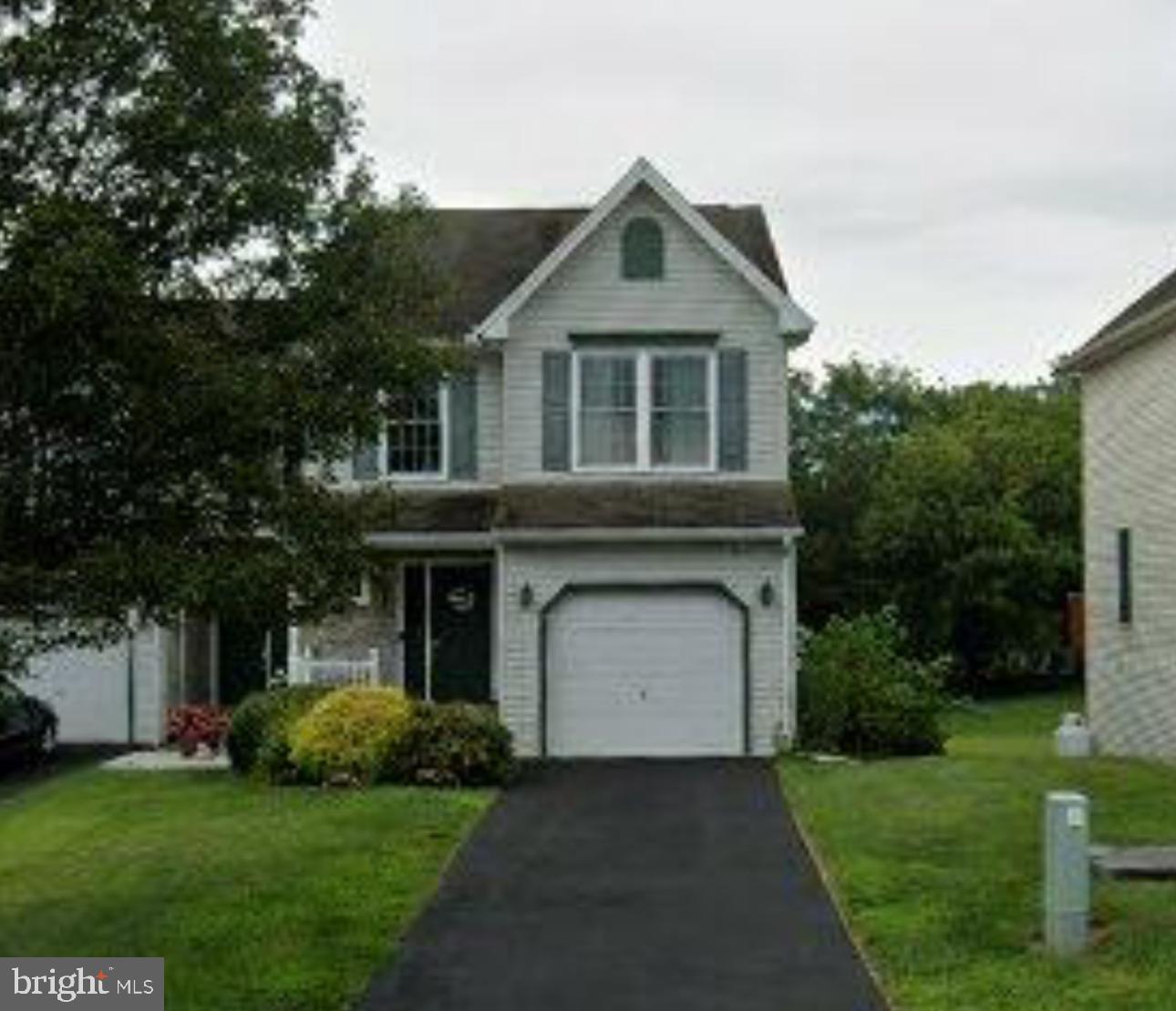 a front view of a house with a garden and garage