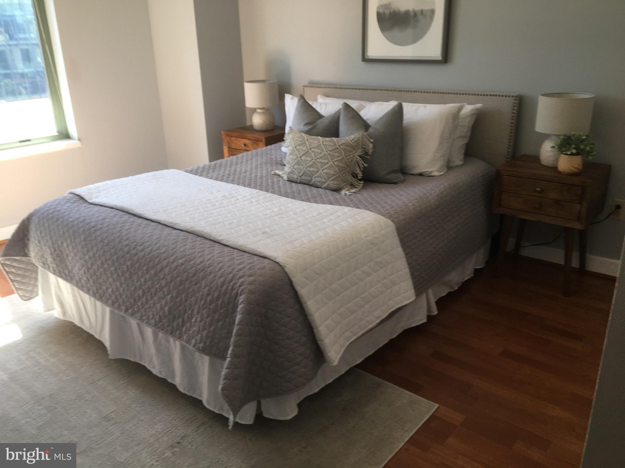 a large bed sitting in a bedroom next to a window