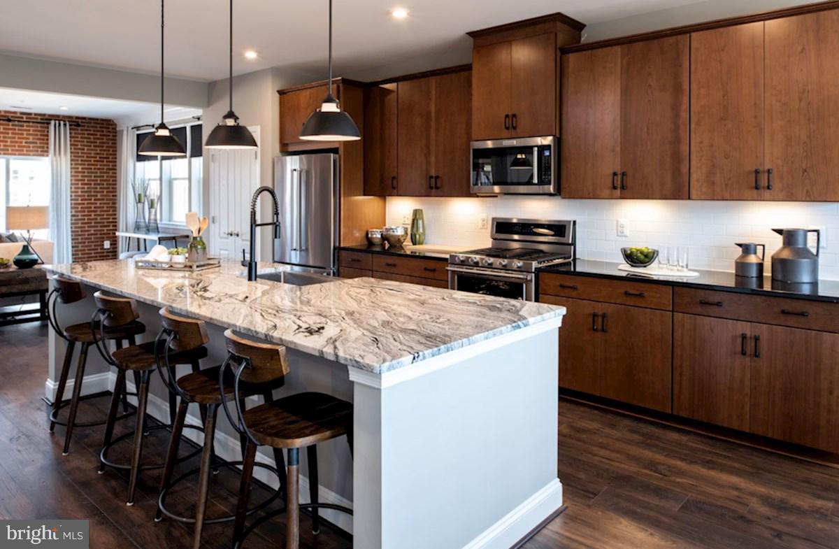 a kitchen with granite countertop wooden cabinets and stainless steel appliances