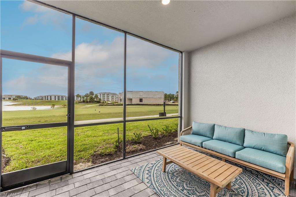 a living room with furniture and a floor to ceiling window