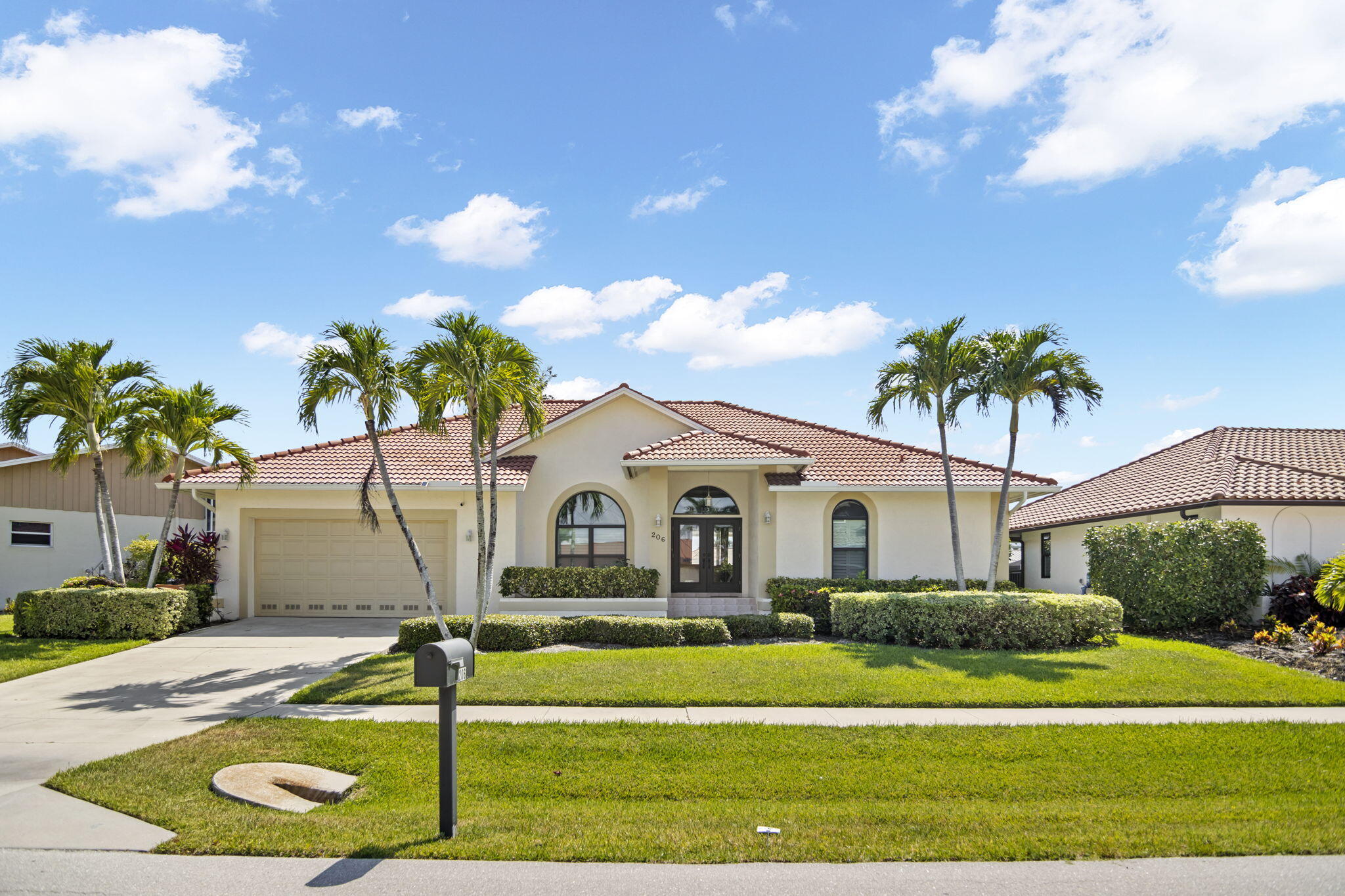 a front view of a house with a yard and swimming pool