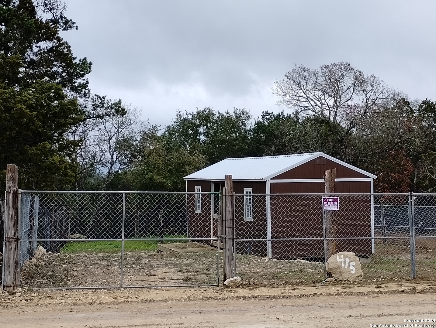 a white house with a small yard and wooden fence