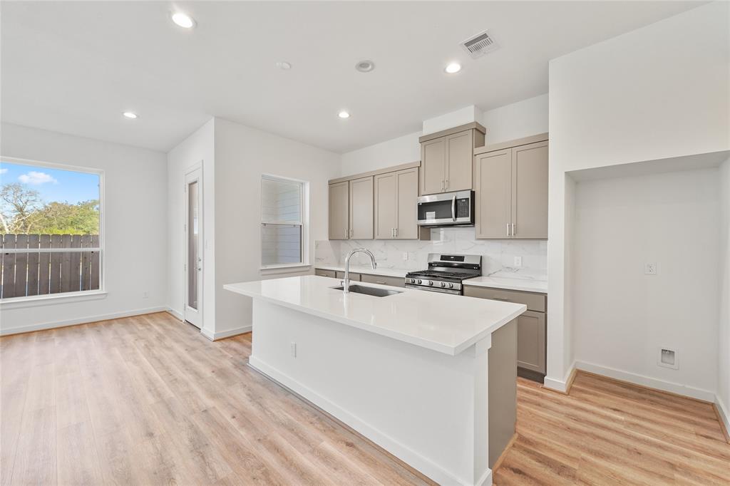 a kitchen with a sink a stove a refrigerator and a microwave