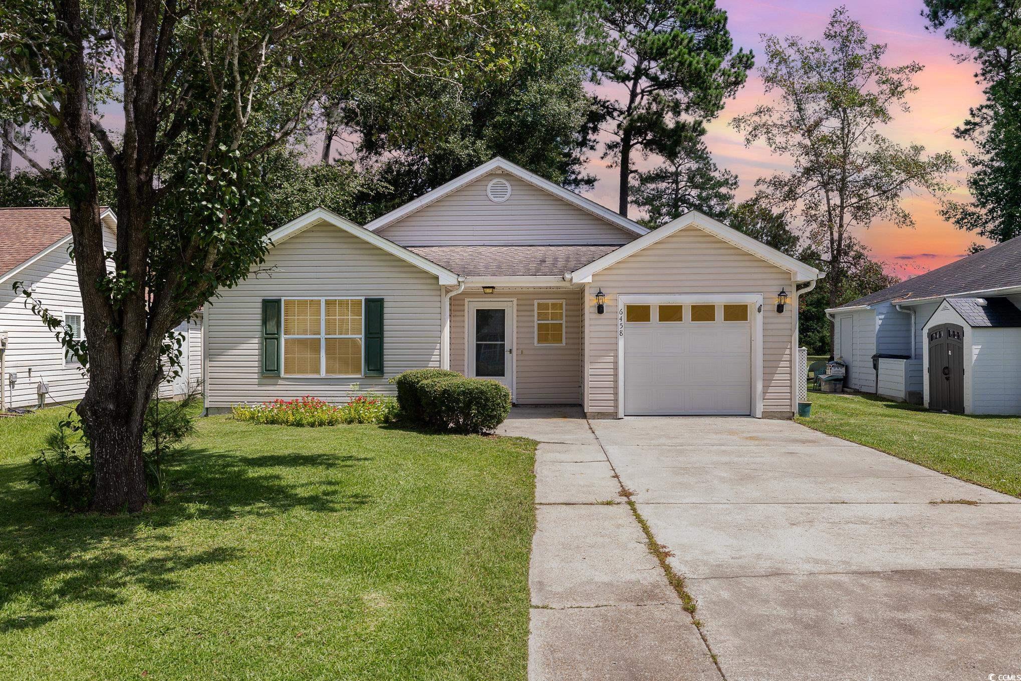 Ranch-style home with a garage and a lawn