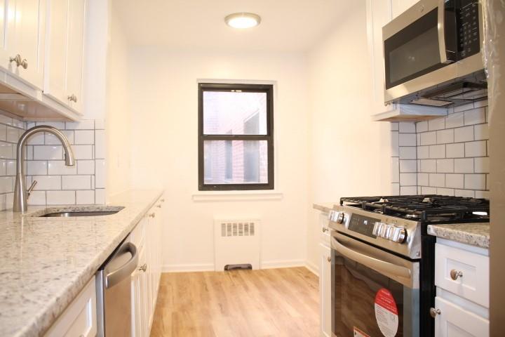 a kitchen with granite countertop a stove and a sink