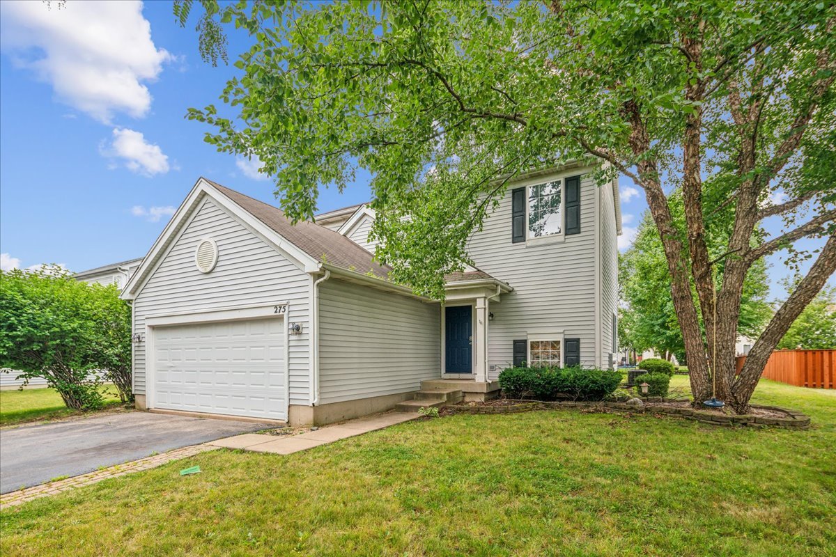 a front view of a house with a yard and garage