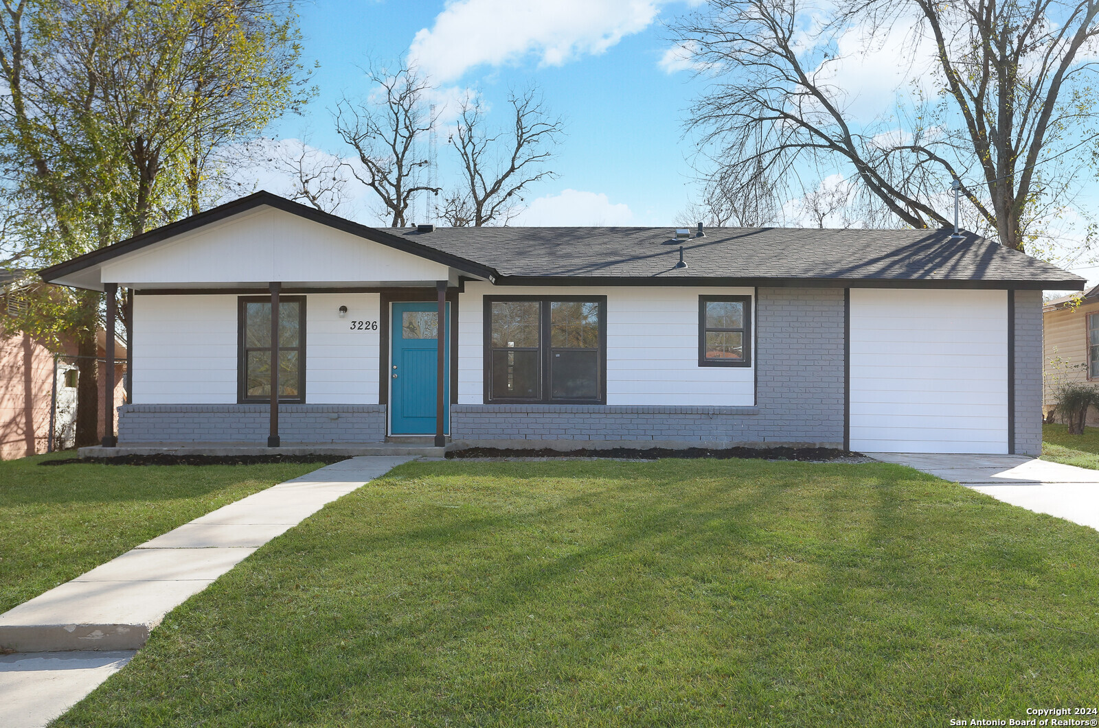 a front view of a house with yard and trees