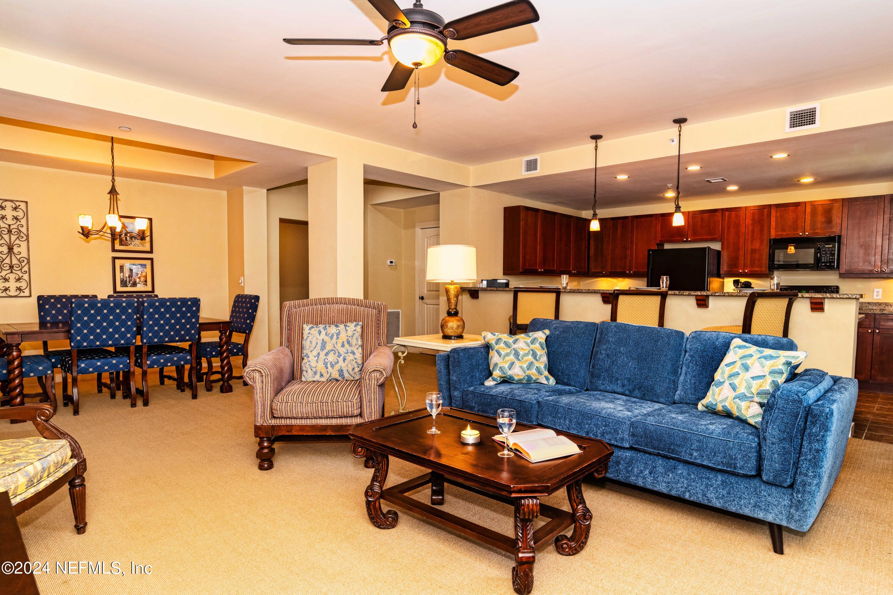 a living room with furniture and kitchen view