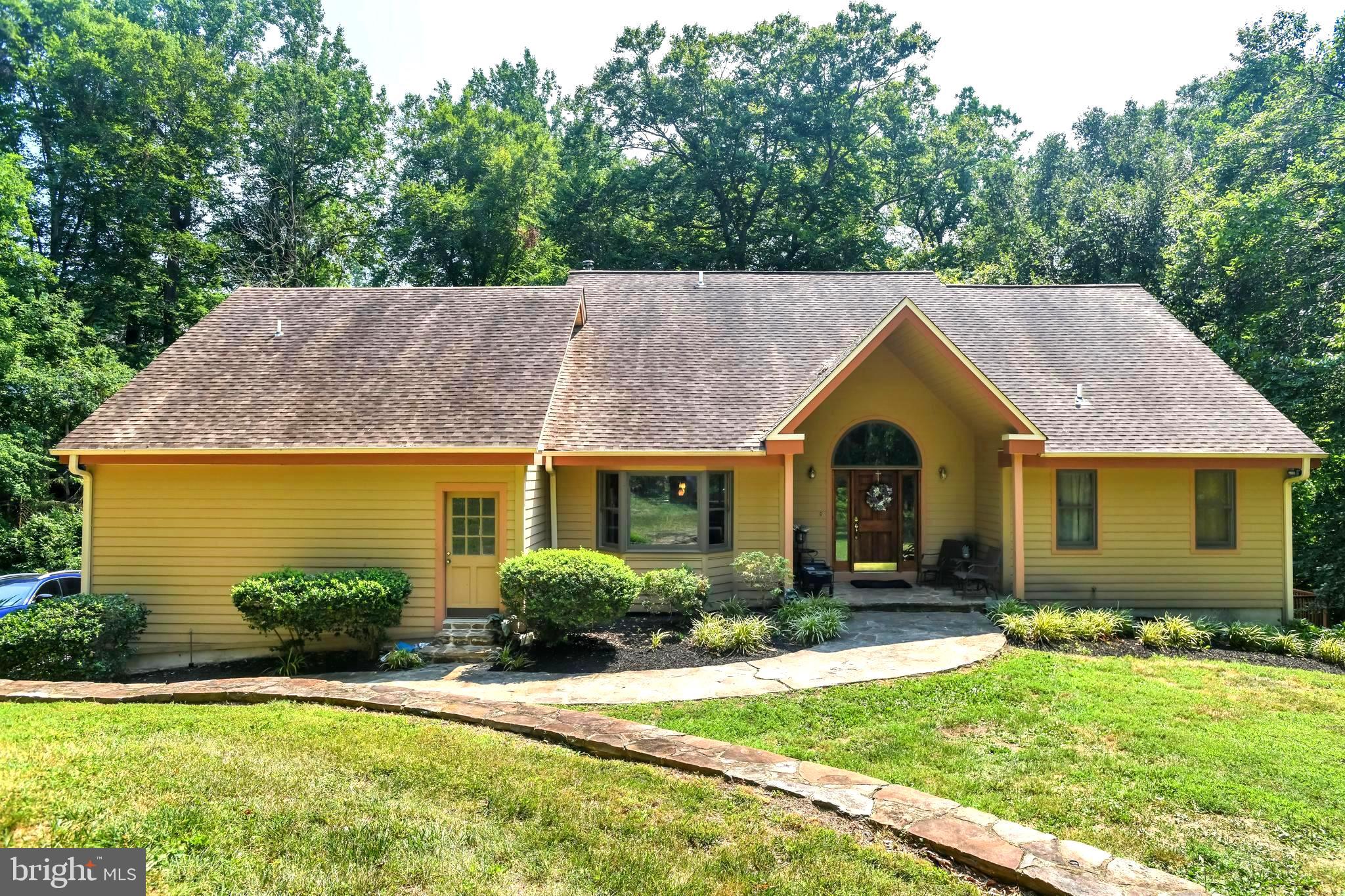 a view of house with garden and tall tree