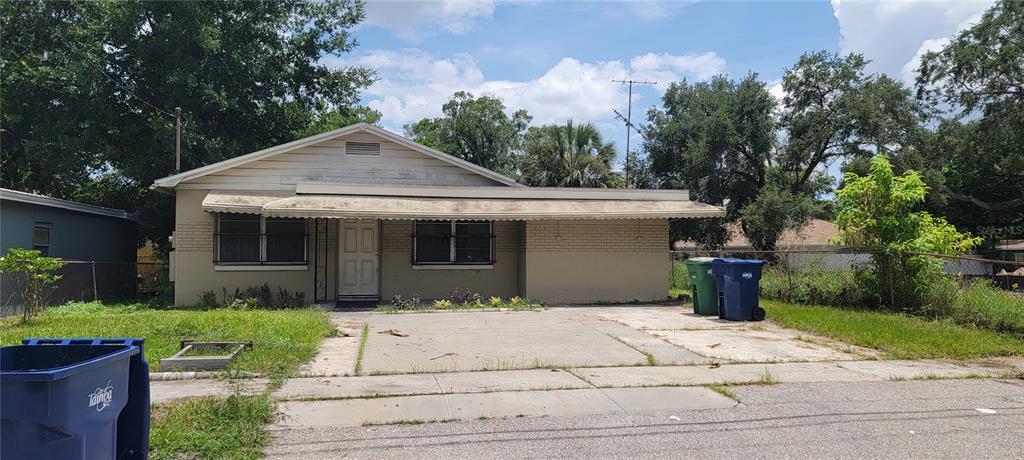 a front view of a house with a yard and potted plants